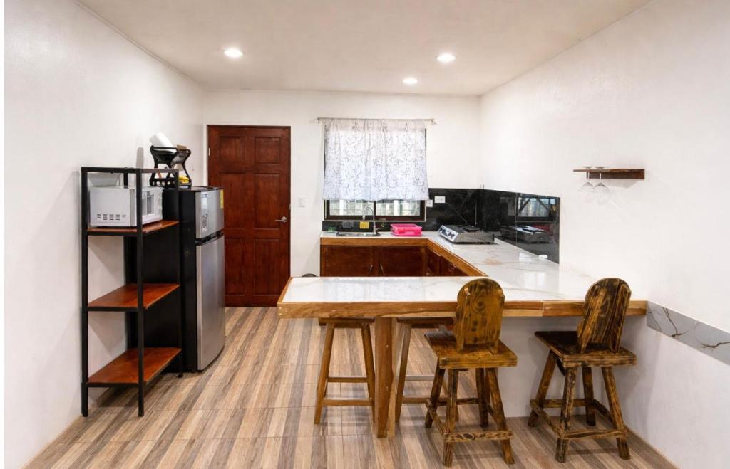a kitchen with a wooden table and a refrigerator at Brisas Griegas in Quepos
