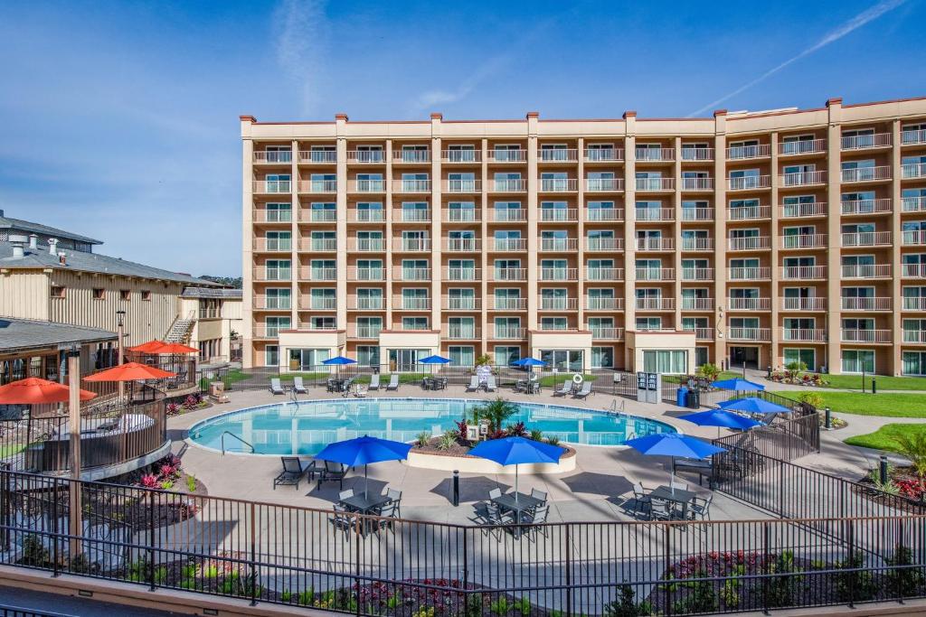 a view of a hotel with a pool and umbrellas at Crowne Plaza San Diego - Mission Valley by IHG in San Diego