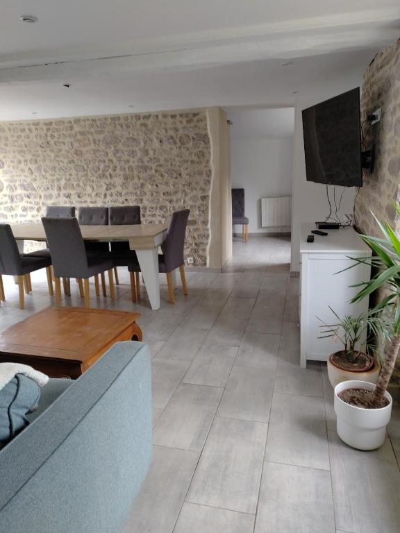 a living room with a couch and a table at L' Eminence in Clécy