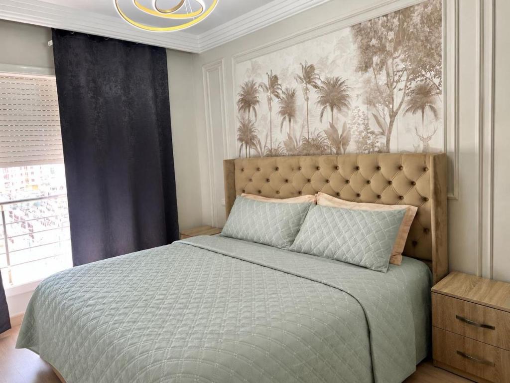 a bedroom with a large bed and a painting on the wall at Appartement Chaleureux et Cosy Proche De sortie autoroute in Mohammedia