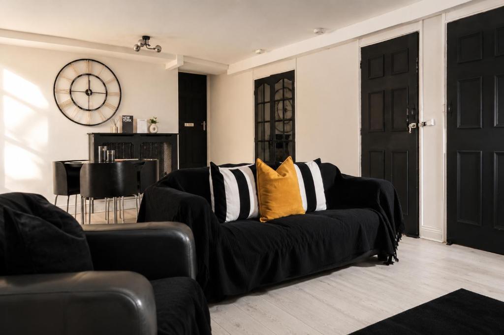 a black couch with yellow pillows in a living room at Newcastle City Centre 2BR, Near Central Train Station in Newcastle upon Tyne