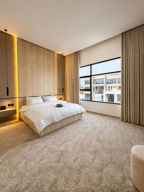 a bedroom with a large bed and a large window at مساكن لينا الفندقية in Abha