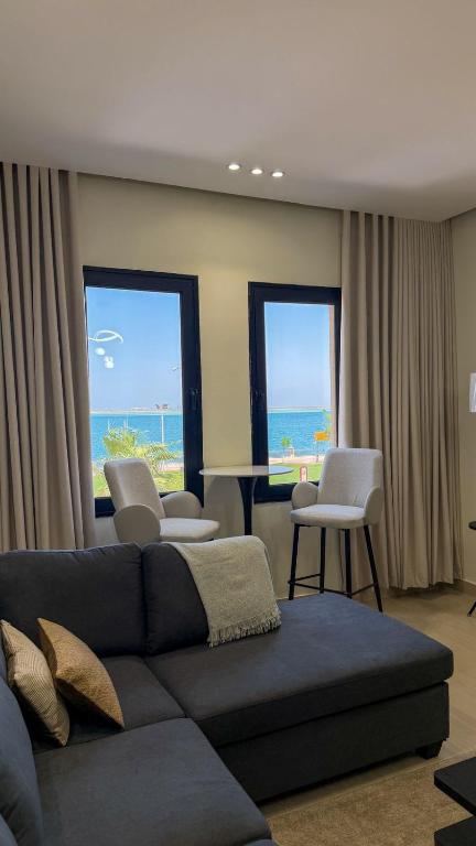 a living room with a couch and chairs and the ocean at Pearl sea in Al Jubail