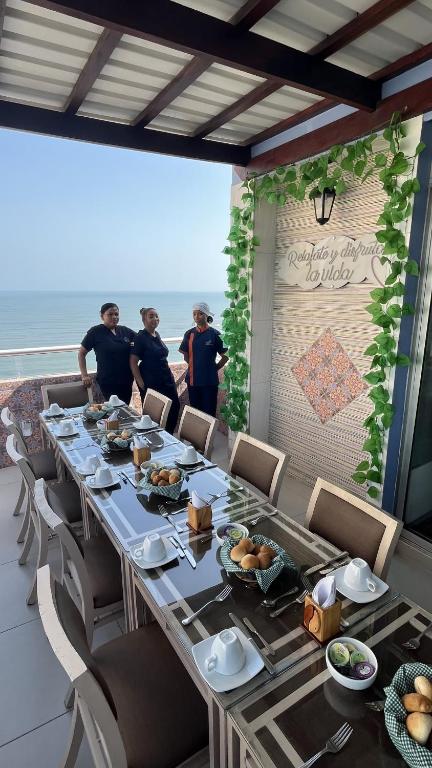a group of people standing around a long table at Hotel Cabreromar in Cartagena de Indias