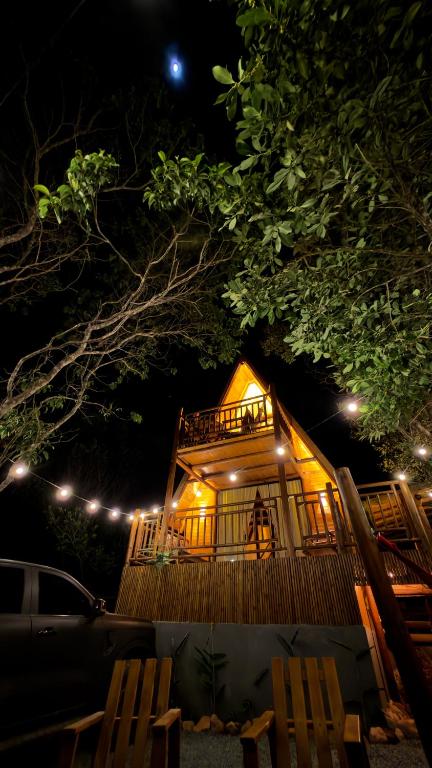a house lit up at night with lights at Chalé Suíco Vale do Capão in Palmeiras