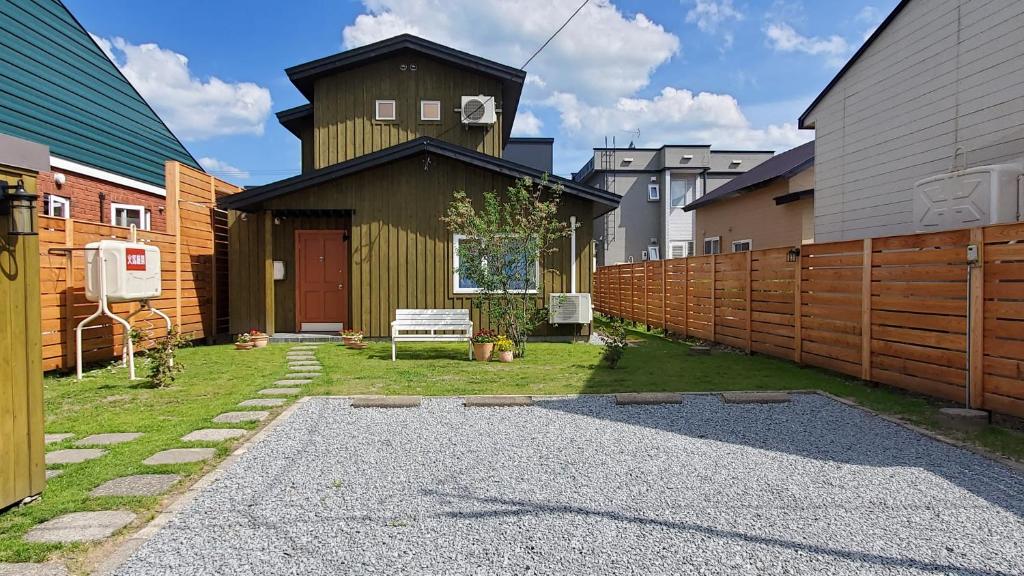 a backyard with a wooden fence and a building at Biei Central Villa 2 - Olive House in Biei