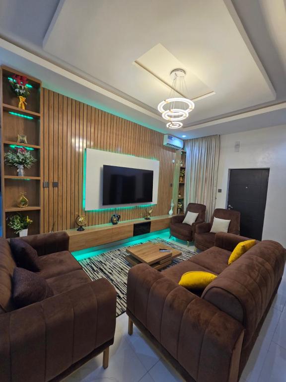 a living room with a couch and a flat screen tv at O2 Continental Suites in Kubwa