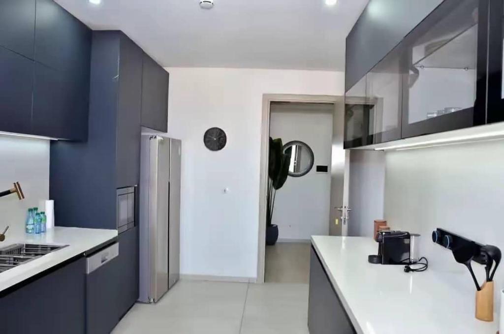 a kitchen with black cabinets and a white counter top at F3 ngor virage in Dakar
