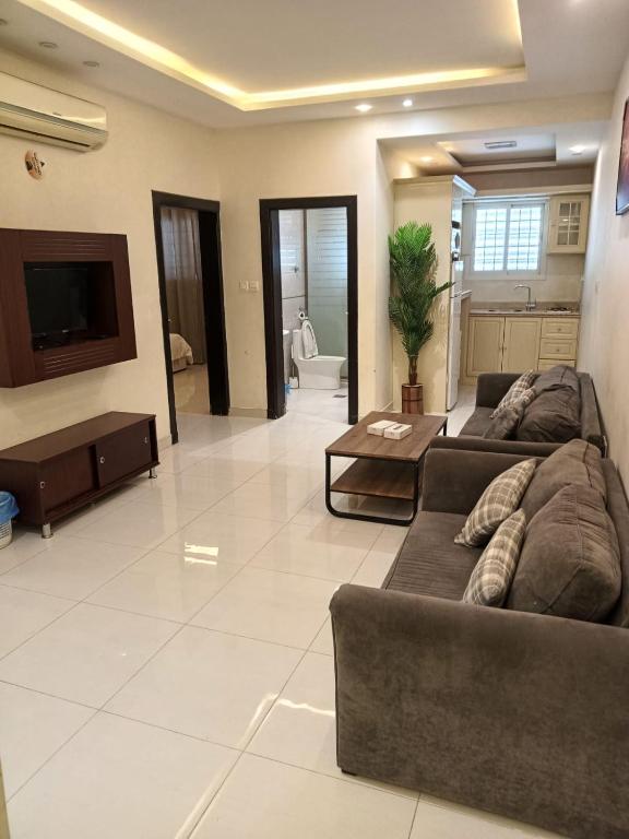 a living room with two couches and a tv at شقق فندقيه in Buraydah