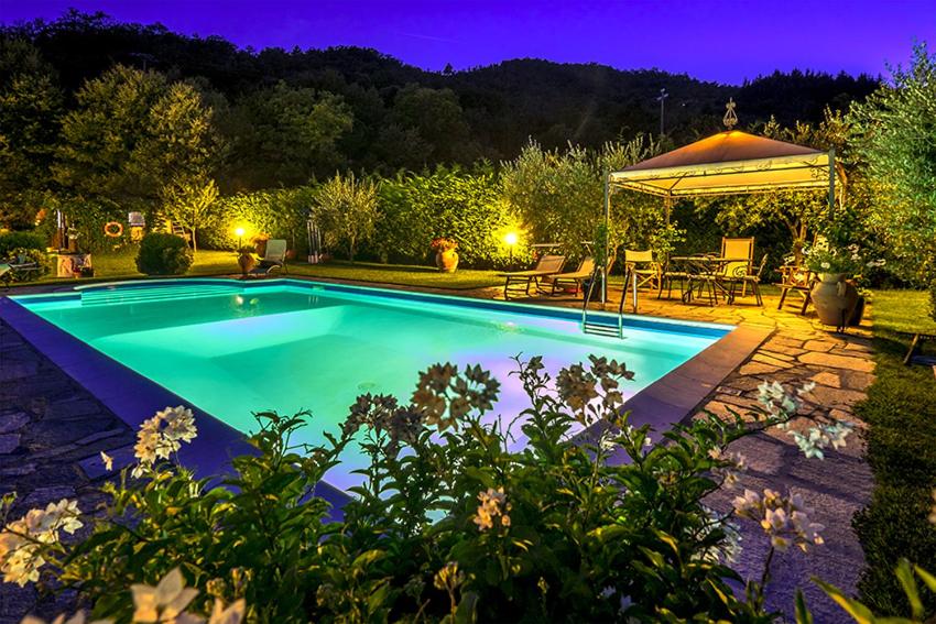 una piscina en un patio por la noche en Villa Il Seccatoio, en Poggioni