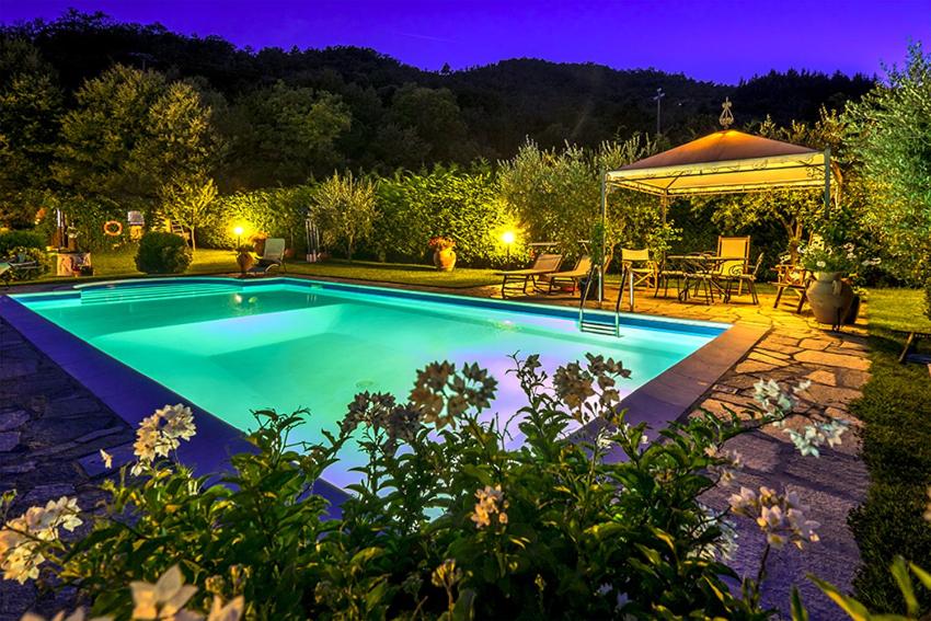 a swimming pool in a yard at night at Villa Il Seccatoio in Poggioni