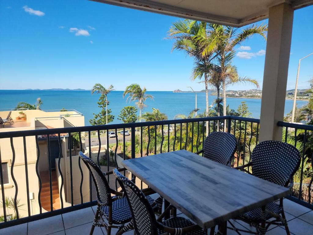 a table and chairs on a balcony with a view of the ocean at Ocean View Villa in Yeppoon