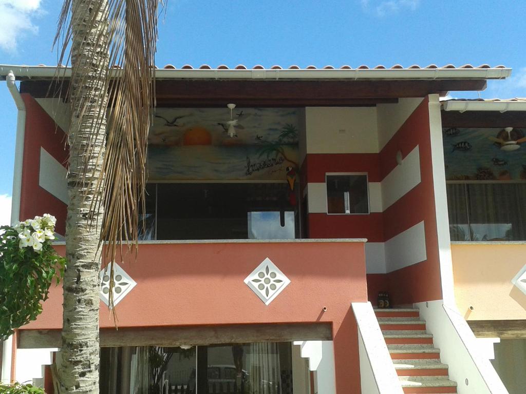 ein Gebäude mit einer Palme davor in der Unterkunft Jardim Atlantico in Paripueira