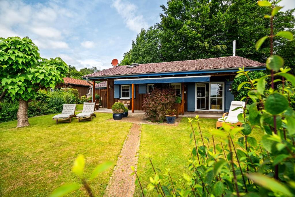 a small house with chairs and a yard at Ferienhaus Kathi - Ihre Auszeit direkt am See in Jabel in Jabel