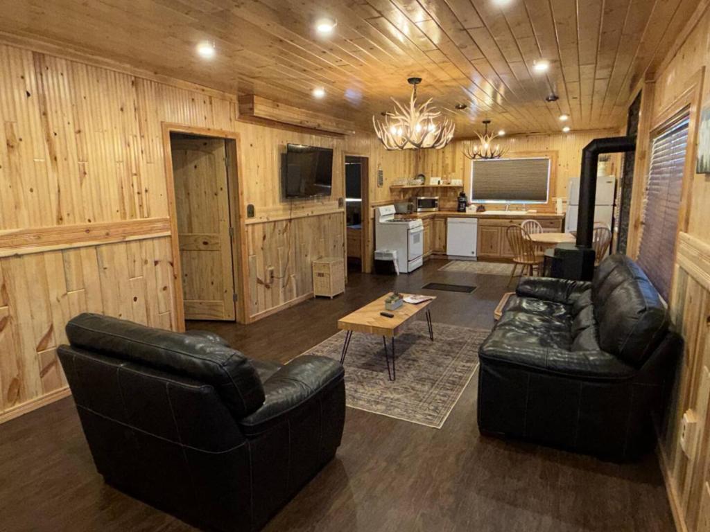 a living room with two leather couches and a television at Bellamy's Ski Haus in Red River