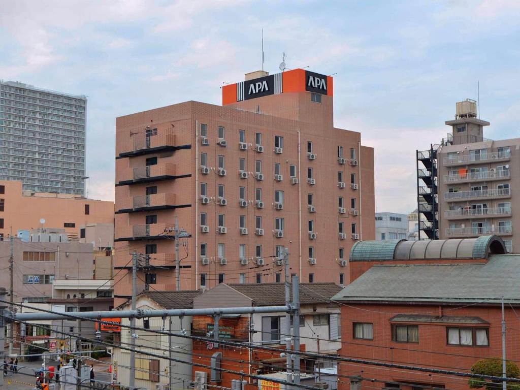 a building with a sign on the top of it at APA Hotel Saitama Ageo-Ekimae in Ageo