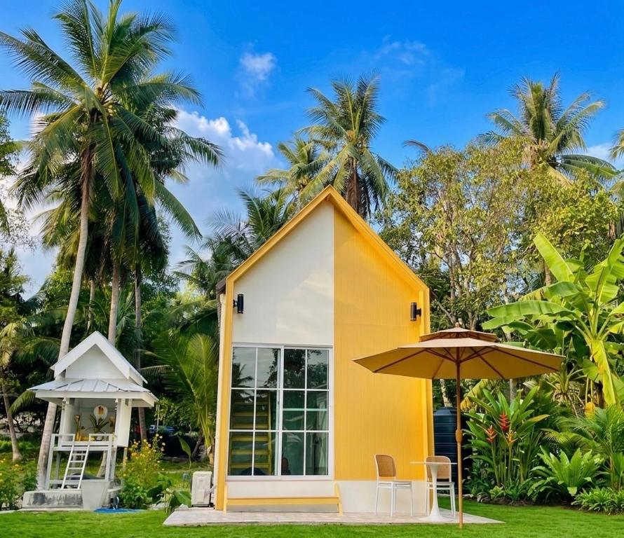 a small yellow and white house with an umbrella at Tiny Secret in Ban Tai