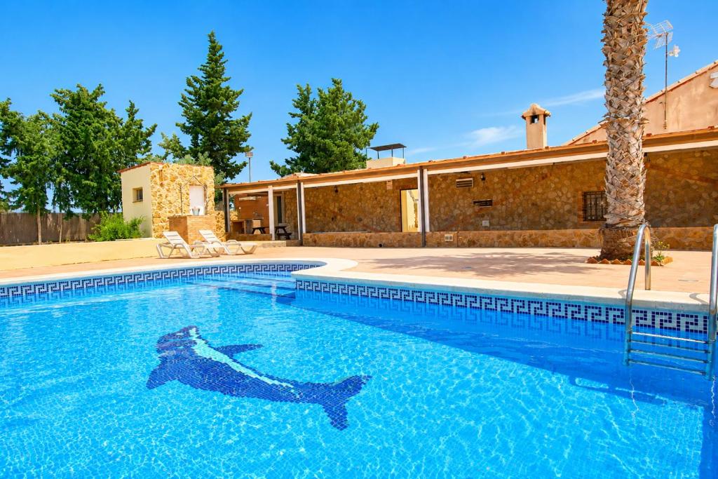 a person laying in the water in a swimming pool at La Casona del Olivo - Pool, Patio, BBQ & Pet-Friendly in Torre-Pacheco
