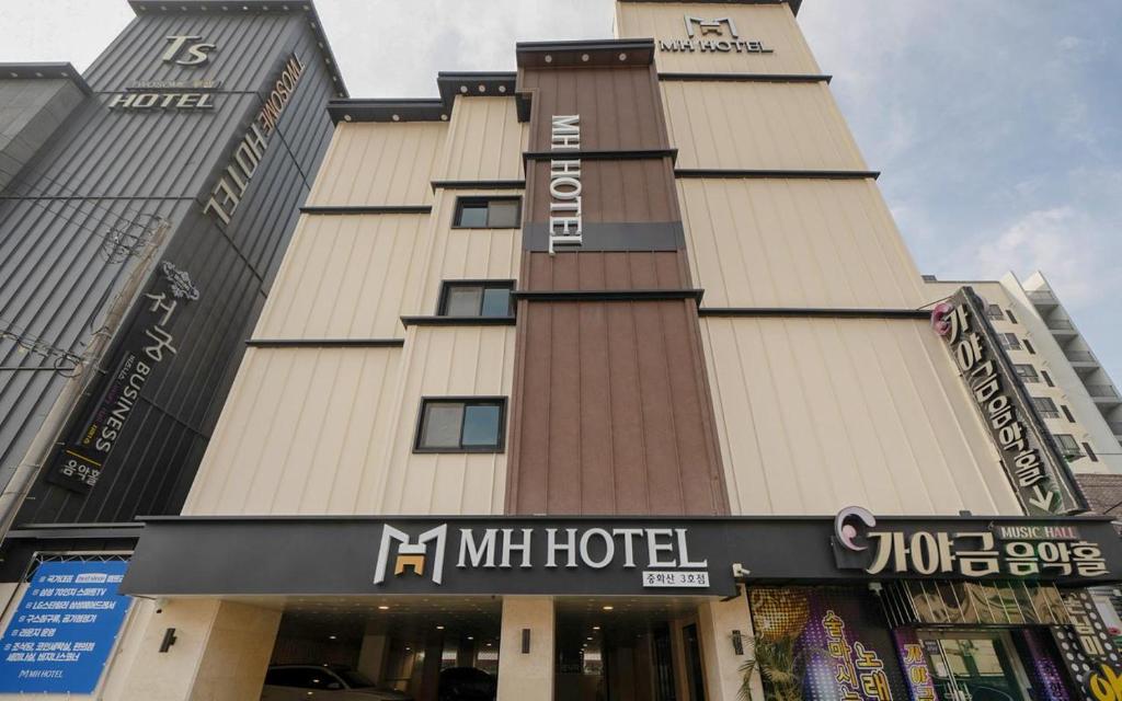 a building with a hotel sign in front of it at MH Hotel 3 - Junghwasan in Jeonju