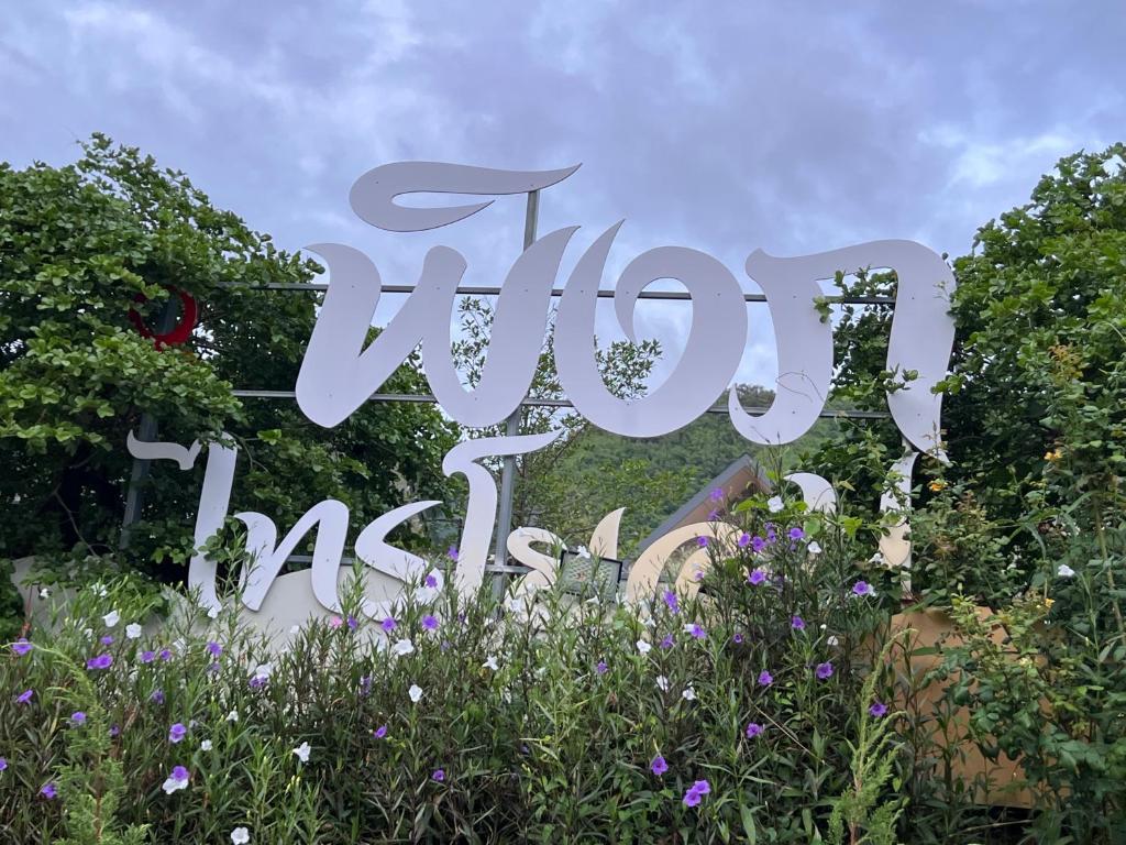 a sign in the middle of a garden with flowers at พิงภู ไทรโยค in Ban Lum Sum (1)