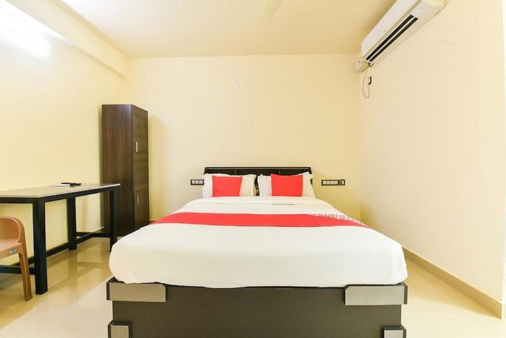 a bedroom with a large bed with red pillows at Hotel O VR Lodge in Pathanāmthitta