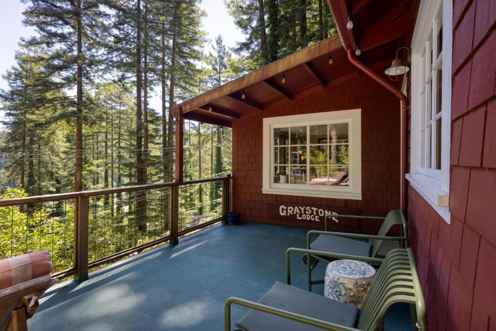 a screened porch of a red house with chairs and a window at Wanderwood in Guerneville