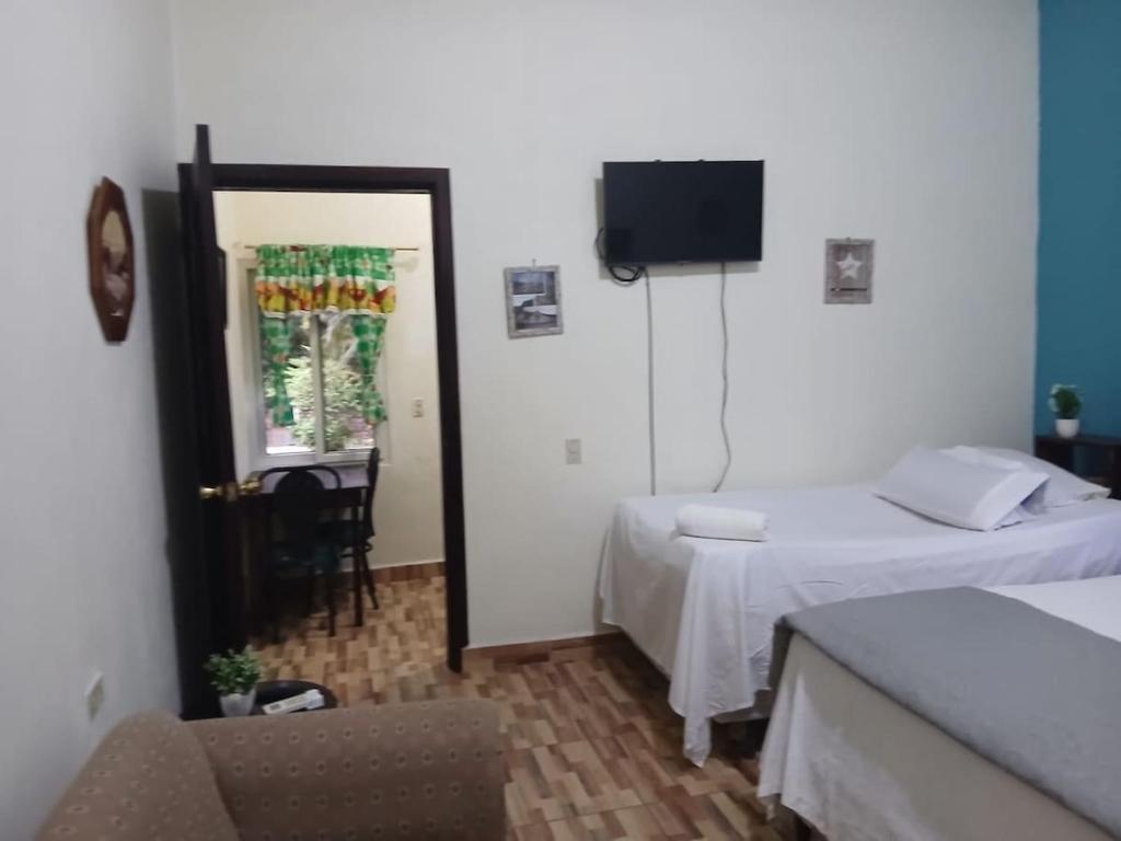 a hotel room with two beds and a television at Casa Miramar Tx in Trujillo