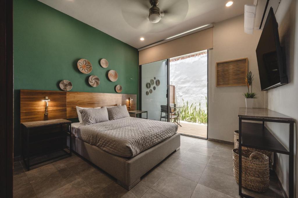 a bedroom with a bed and a green wall at Suites con piscina privada - Penca Suites Valladolid in Valladolid