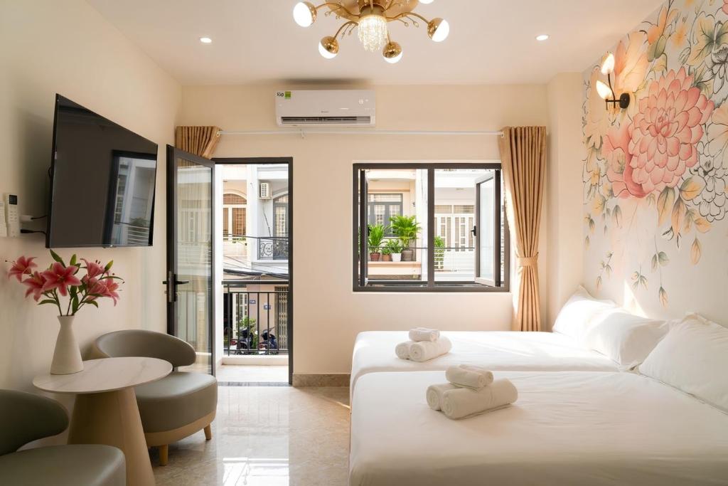 a living room with a white bed and a table at The Pivot Suite Ben Thanh - District 1 in Ho Chi Minh City