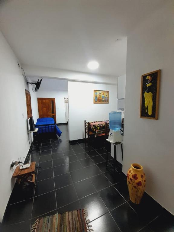 a living room with a black tile floor and a room at Departamento Briana in Villa Unión