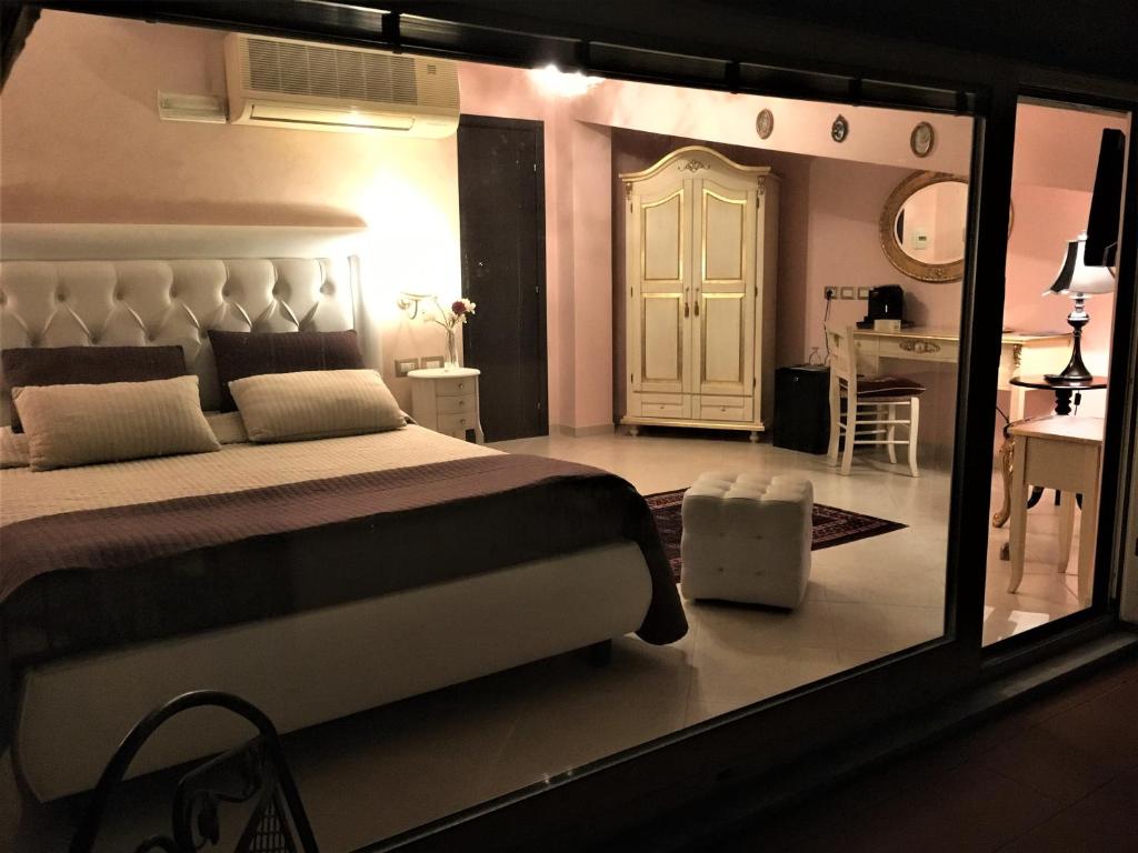 a bedroom with a large white bed and a door at Hotel Scilla in Scilla