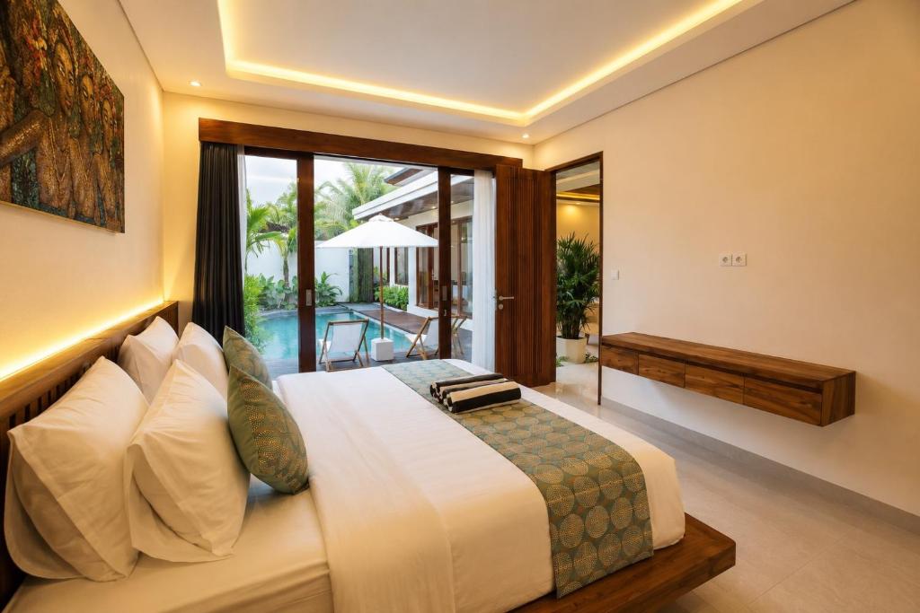 a bedroom with a large bed and a balcony at Denaya Villa in Ubud