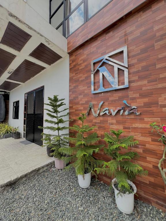 a sign on the side of a building with plants at Navia in Sañgitan