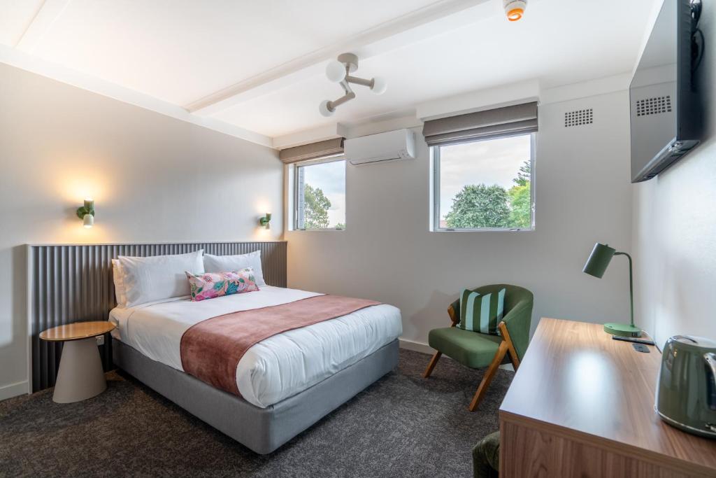 a bedroom with a bed and a desk and a chair at Doonside Hotel, Blacktown in Doonside
