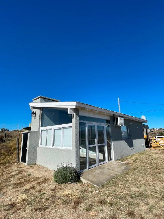 a small house on a field with a blue sky at Templanza in Villa Yacanto