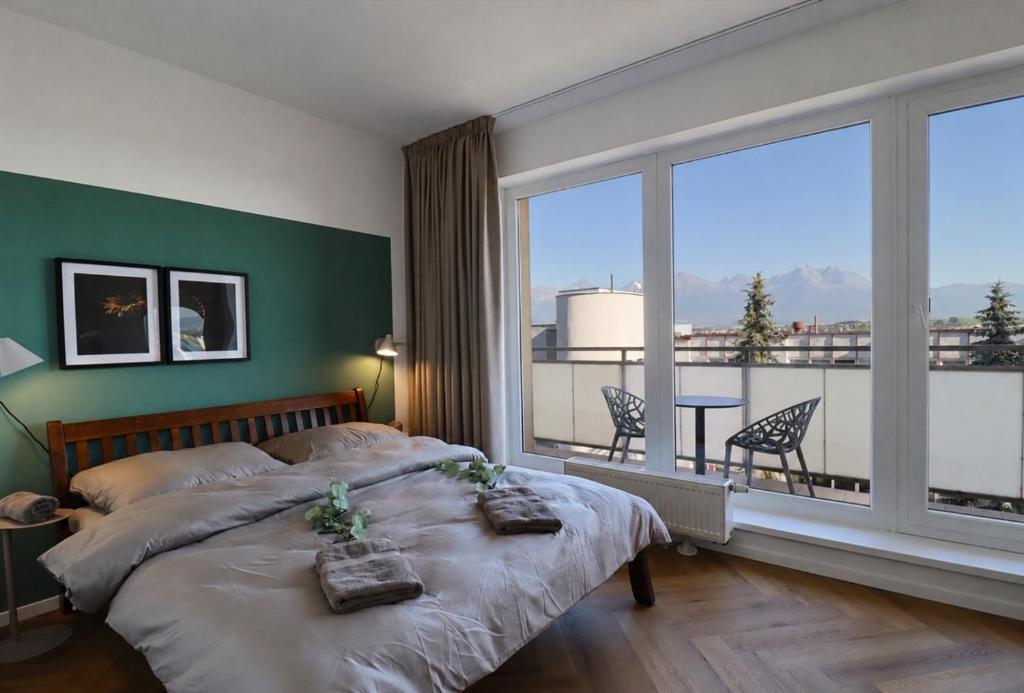 a bedroom with a bed and a large window at APARTMENT A&D Monaco in Poprad