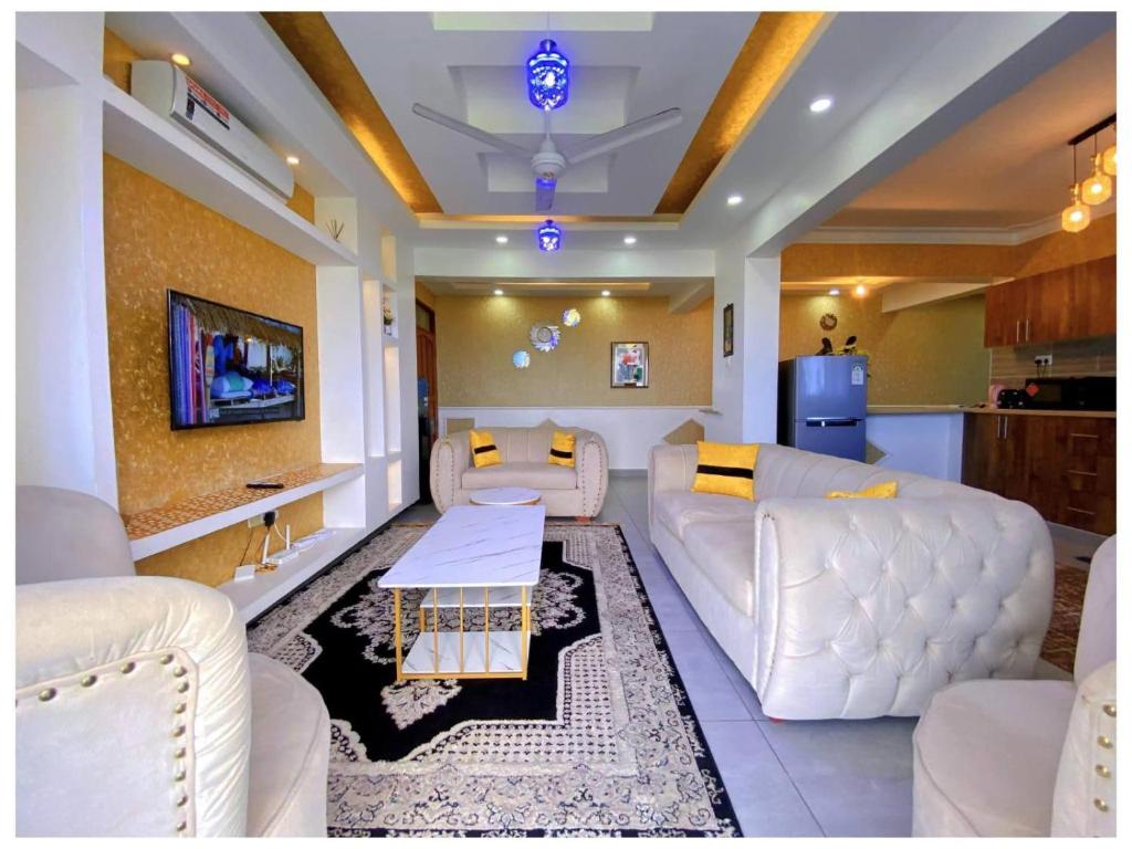 a living room with white couches and a table at Nyali Glam Apartment in Mombasa