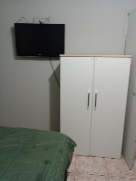 a white cabinet with a television on top of it at Rua da Expo Itaguaí in Itaguaí