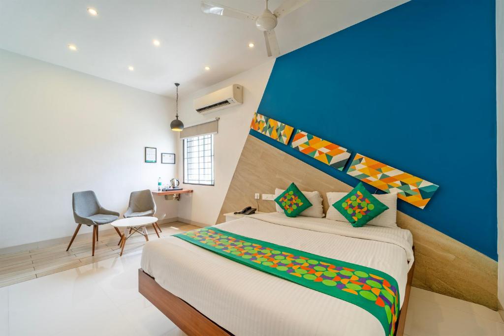 a bedroom with a large bed with a blue wall at Treebo Premium Corner Stay in Coimbatore