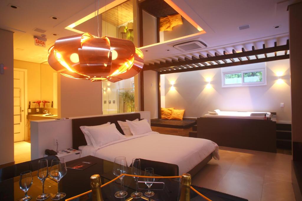 Zaya Motel Premium في فلوريانوبوليس: غرفة نوم بسرير وطاولة في غرفة