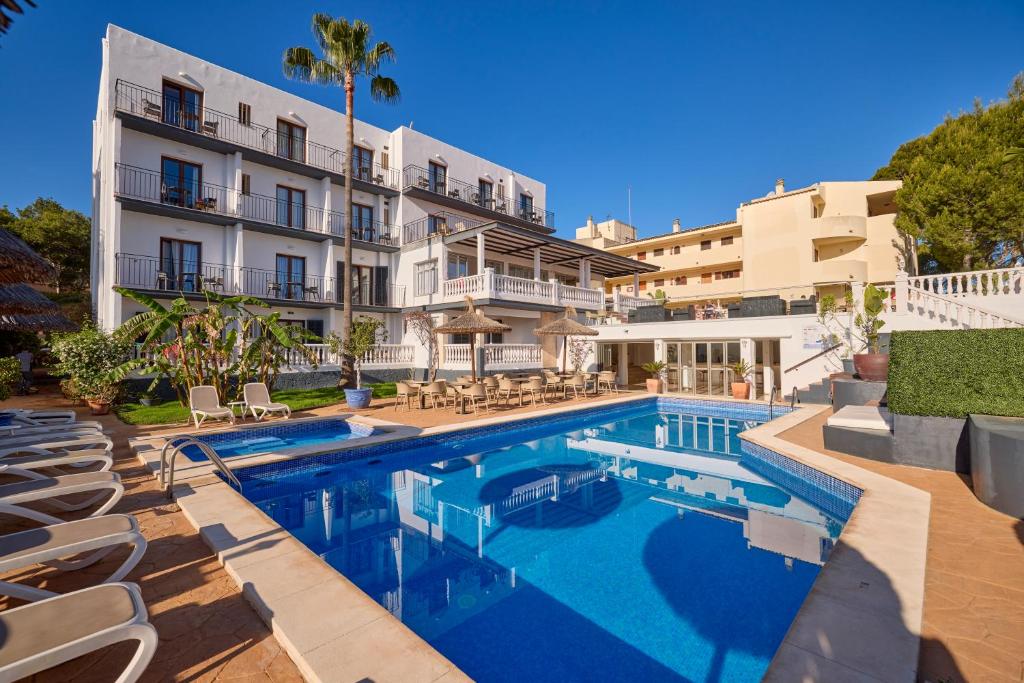 a swimming pool in front of a building at Hotel Navia Santa Ponsa - Adults Only in Santa Ponsa
