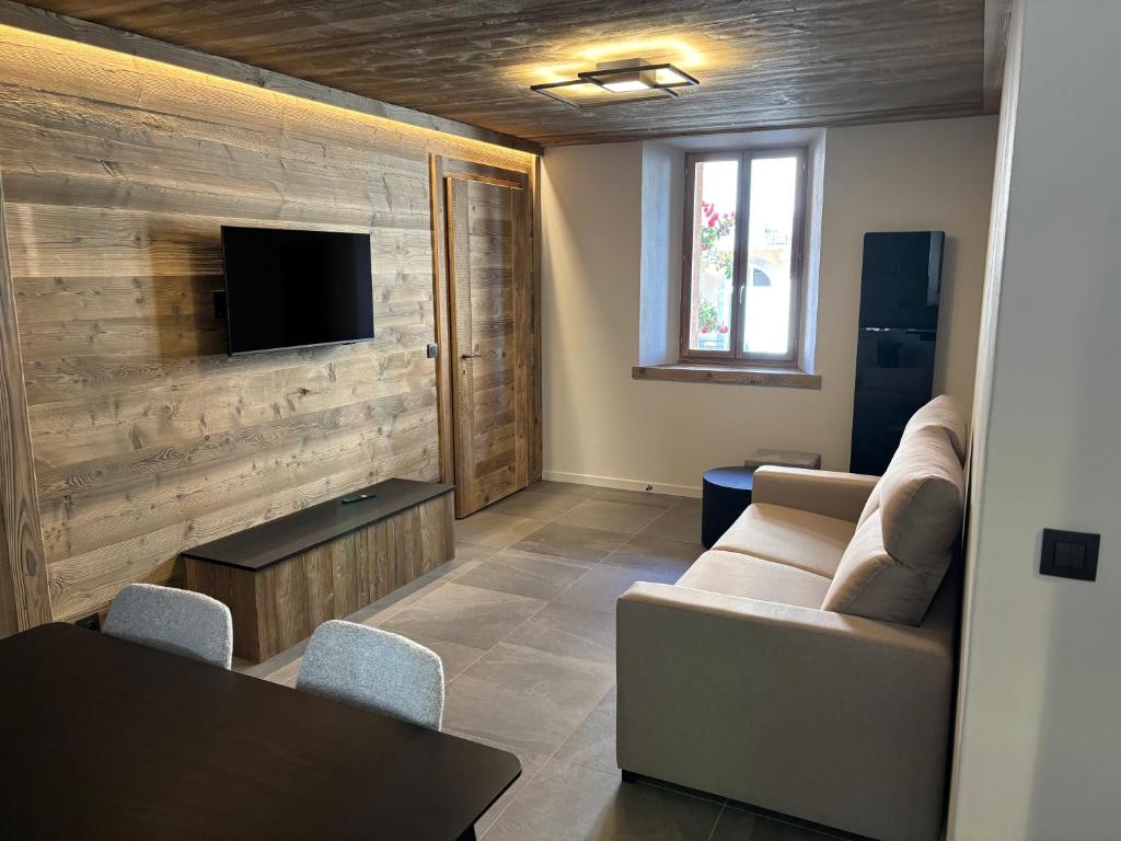 a living room with a couch and a television on a wall at Mont Joly 2 in Le Baplieu