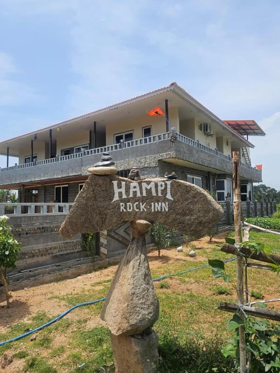 a house with a rock sign in front of it at Hampi Rock-Inn in Hampi