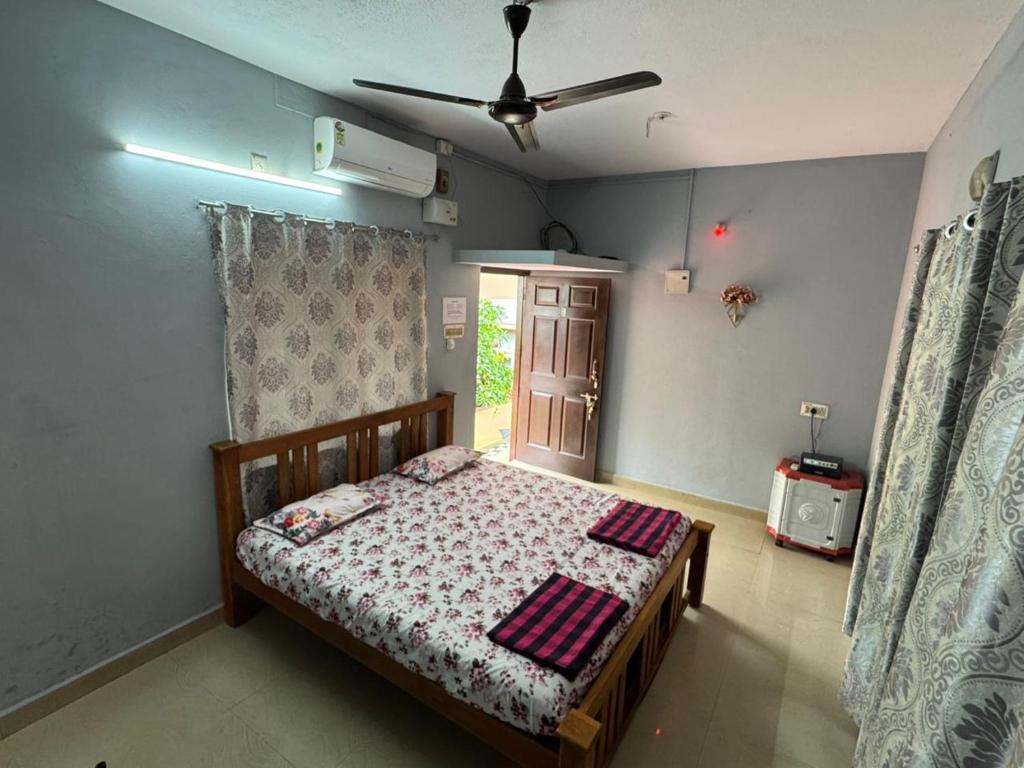 a bedroom with a bed and a ceiling fan at KENSON HOMESTAY in Mangalore