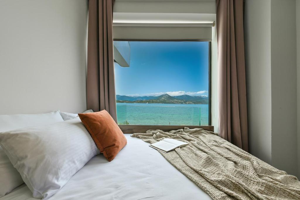 a bedroom with a window with a view of the water at Ciel Seafront Suites - Maisonette in Lygia