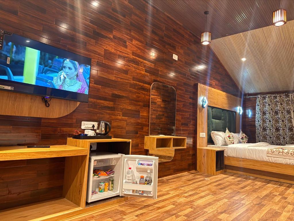 a room with a tv on a wooden wall at The Cedar Pahalgam in Pahalgām
