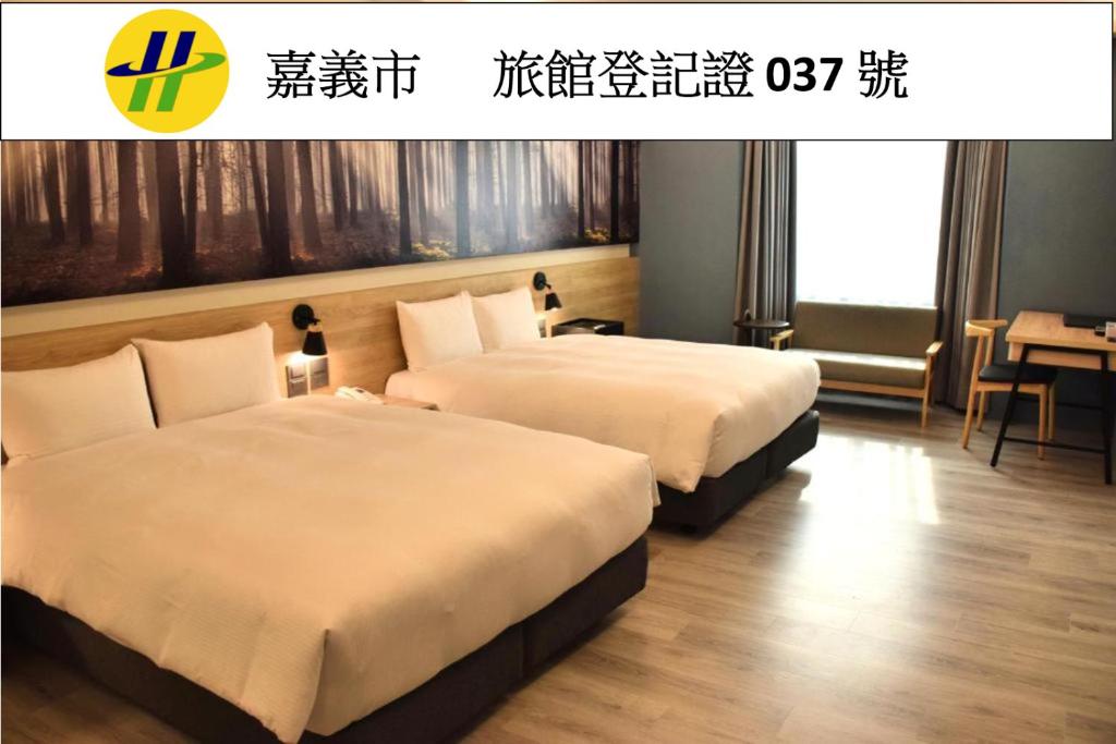 a hotel room with two beds in a room at Yoyo Hotel in Chiayi City