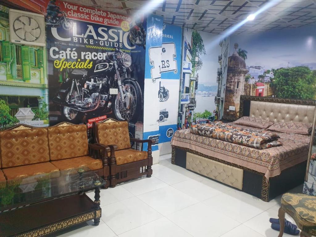 a room with a bed and a chair and a poster at Hotel Melodyinn in Gujrāt