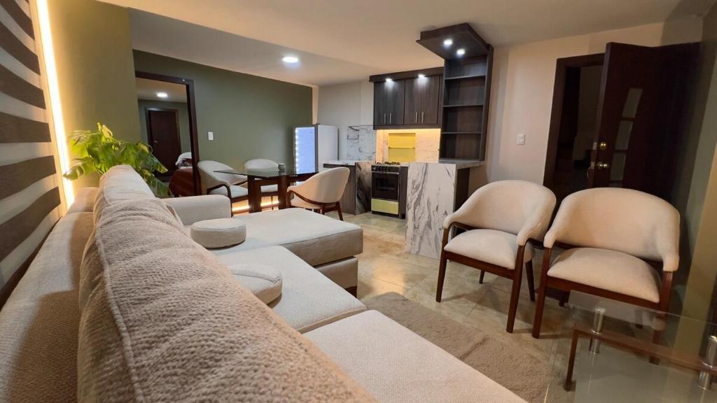 a living room with a couch and chairs and a kitchen at Spacious Suite privacy, and comfort in Riobamba