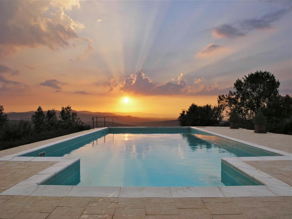 a swimming pool with a sunset in the background at Casa del Tramonto in Civitella in Val di Chiana